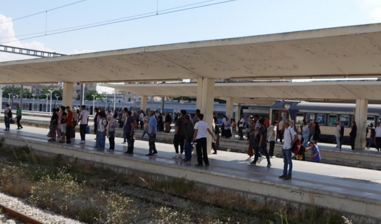 Im Hauptbahnhof Tunis fährt der Zug nicht ins angekündigte Gleis ein, sodass die Leute einfach über die Schienen zum anderen Bahnsteig klettern.